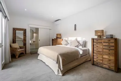 a bedroom with a bed and a dresser and a mirror at A Casa Di Renucci by Alfred in Bali in Seminyak