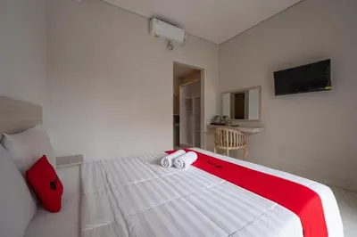 a bedroom with a bed with two towels on it at RedDoorz Plus at Yasa's Living Denpasar in Sanur