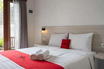 a bedroom with a large bed with two towels on it at RedDoorz Plus at Yasa's Living Denpasar in Sanur