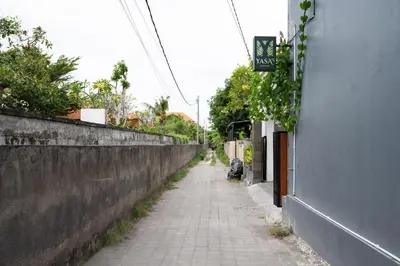 an empty alley way next to a wall at RedDoorz Plus at Yasa's Living Denpasar in Sanur