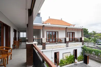 a balcony of a house with tables and chairs at RedDoorz Plus at Yasa's Living Denpasar in Sanur