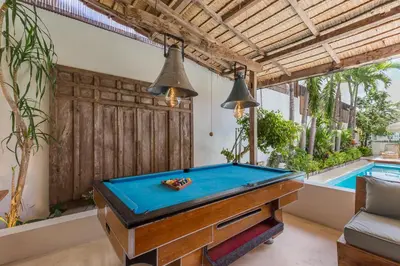 a pool table in a room next to a swimming pool at 7BR Villa Private Pool Yoga Gym Cinema 10min Canggu Surfing Beach in Kerobokan