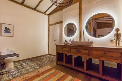 a bathroom with a sink and a toilet and mirrors at 7BR Villa Private Pool Yoga Gym Cinema 10min Canggu Surfing Beach in Kerobokan
