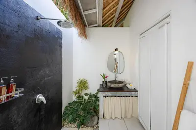 a bathroom with white walls and a mirror at Newly renovated Villa Noa by Optimum Bali Villas in Seminyak