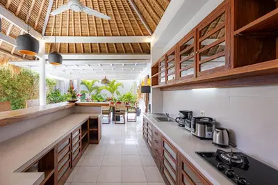 an open kitchen with wooden cabinets and counter tops at Newly renovated Villa Noa by Optimum Bali Villas in Seminyak
