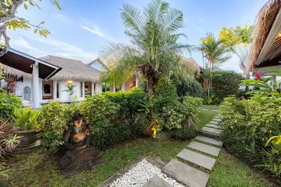 a garden with a statue in front of a house at Newly renovated Villa Noa by Optimum Bali Villas in Seminyak