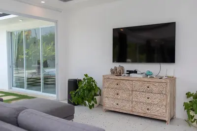 a living room with a couch and a tv on a wall at Villa Vulla in Seminyak