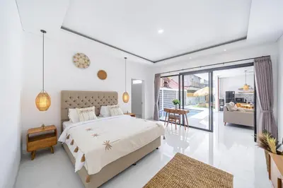 a bedroom with a large bed and a living room at New Modern Villa in Bali in Legian
