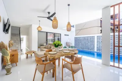 a dining room with a table and chairs and a pool at New Modern Villa in Bali in Legian