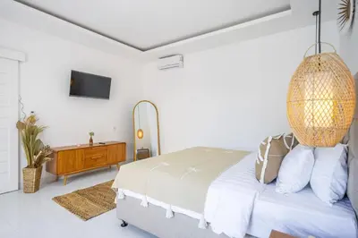 a white bedroom with a bed and a chandelier at New Modern Villa in Bali in Legian