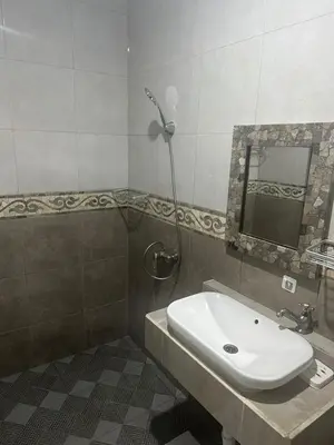 a bathroom with a sink and a shower at Pudak Sari Homestay in Kuta