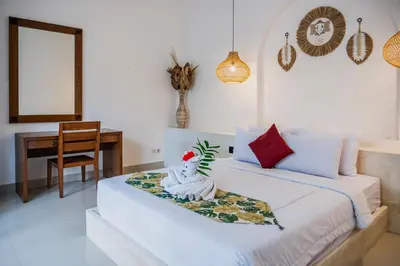 a bedroom with a bed with a statue on it at Umah Kita Villa in Seminyak