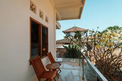 a balcony with two chairs and a table at Umah Kita Villa in Seminyak