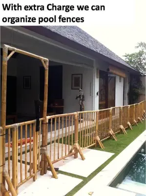 a house with a wooden fence next to a pool at Sol Bella VIlla 1 in Seminyak