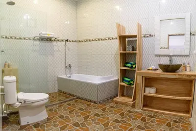 a bathroom with a tub and a toilet and a sink at Sol Bella VIlla 1 in Seminyak