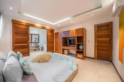 a bedroom with a large bed and a television at Villa Cuatro : Amazing 3BR Villa in Seminyak - Perfect Location in Seminyak