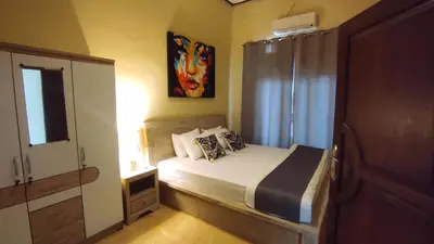 a small bedroom with a bed and a window at Moara Guest House in Kerobokan