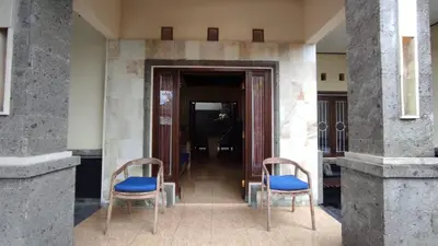 two chairs sitting in front of a building at Moara Guest House in Kerobokan