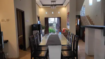 a dining room with a long table and chairs at Moara Guest House in Kerobokan