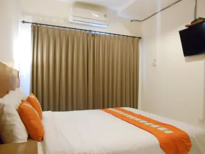 a hotel room with a bed and a window at Tama Seminyak Town House in Kerobokan