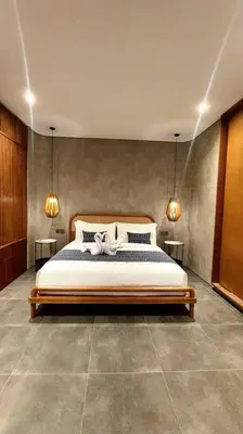 a bedroom with a bed with two lights on the wall at Villa Akhila 2 - 2 BR modern tropical villa at the heart of Seminyak in Seminyak