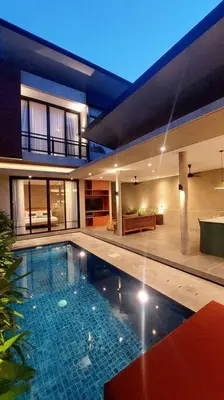 a large house with a swimming pool in front of it at Villa Akhila 2 - 2 BR modern tropical villa at the heart of Seminyak in Seminyak