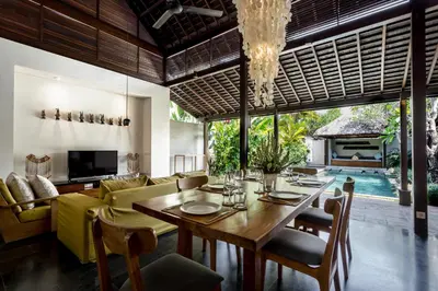 a dining room and living room with a table and chairs at Bumbak Park Villas By Nakula in Canggu