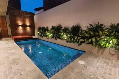 a swimming pool with plants on a wall at Akhila 3 - 2 BR Modern tropical villa at the heart of Seminyak in Seminyak