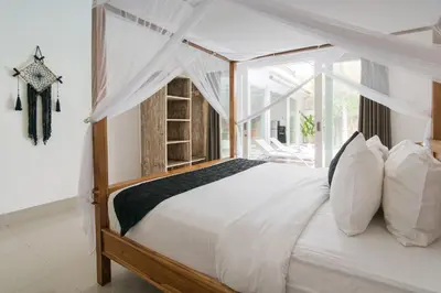 a bedroom with a white bed with a canopy at Modern villa near Atlas beach club & beach in Canggu