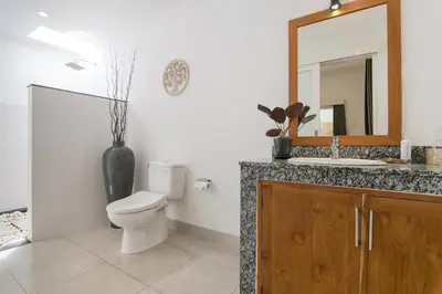 a bathroom with a toilet and a sink and a mirror at Modern villa near Atlas beach club & beach in Canggu