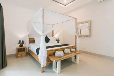 a bedroom with a canopy bed and a wooden table at Modern villa near Atlas beach club & beach in Canggu
