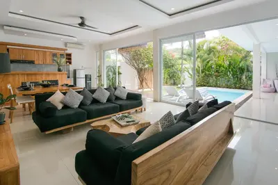 a living room with black couches and a pool at Modern villa near Atlas beach club & beach in Canggu
