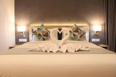 a bed with two swans made out of towels at Anagata Hotels and Resorts Tanjung Benoa in Nusa Dua