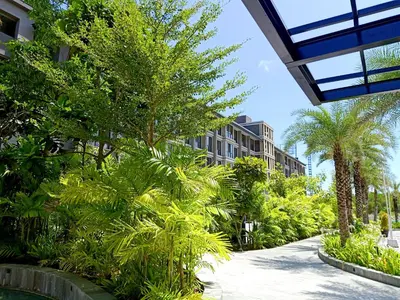a street with palm trees and a building at Anagata Hotels and Resorts Tanjung Benoa in Nusa Dua