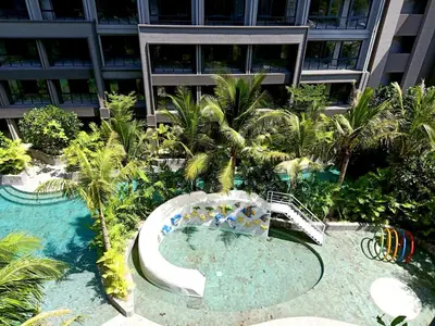 a swimming pool with a slide in front of a building at Anagata Hotels and Resorts Tanjung Benoa in Nusa Dua
