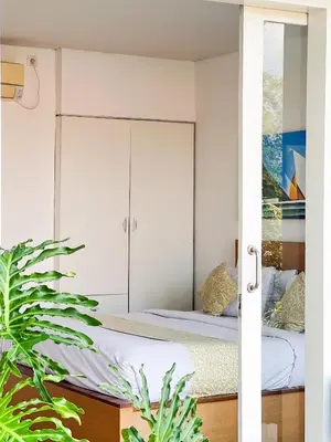 a bedroom with two beds and a mirror at Apple Suite in Kerobokan