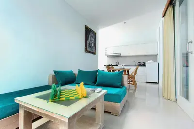 a living room with a blue couch and a table at Apple Suite in Kerobokan