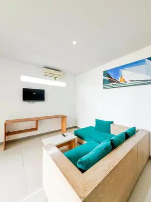 a living room with a couch and a tv at Apple Suite in Kerobokan