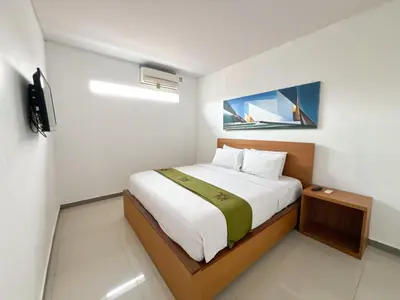 a bedroom with a bed in a white room at Apple Suite in Kerobokan