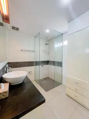 a bathroom with a sink and a glass shower at Apple Suite in Kerobokan