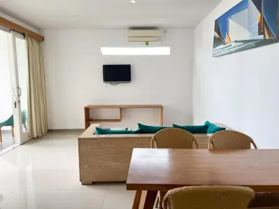 a living room with a couch and a table at Apple Suite in Kerobokan