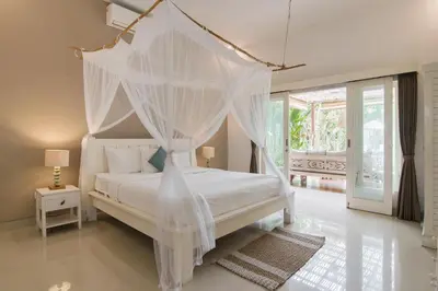 a bedroom with a white bed with mosquito netting at Incredible villa near Atlas beach club Berawa in Canggu