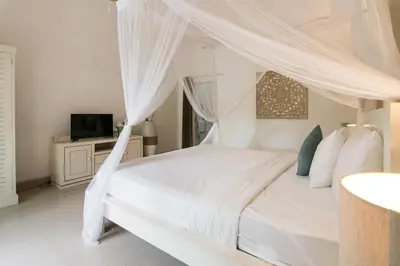 a bedroom with a white bed with a canopy at Incredible villa near Atlas beach club Berawa in Canggu