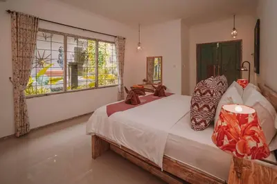 a bedroom with a large bed and a window at Bohemian Kasya Villa Bali in Seminyak