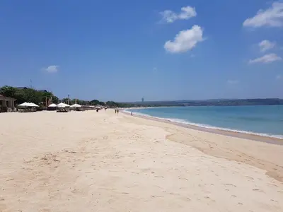 a sandy beach with umbrellas and the ocean at Bali - Jimbaran Beach Villa Private Pool in Jimbaran