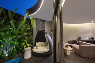 a living room with a couch and a large plant at Je Ne Sais Quoi Seminyak in Seminyak