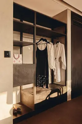 a wardrobe with clothes hanging in a room at Je Ne Sais Quoi Seminyak in Seminyak