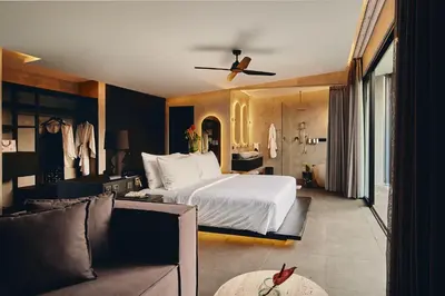 a bedroom with a large bed and a couch at Je Ne Sais Quoi Seminyak in Seminyak