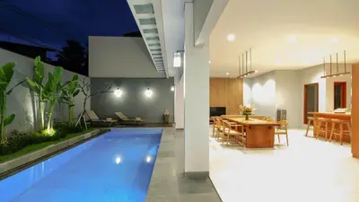 a house with a swimming pool next to a dining room at Modern spacious private pool villa in Central Canggu in Canggu