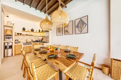 a dining room with a wooden table and chairs at Villa Waikiki - Brand New 4BDR with huge Pool in Seminyak